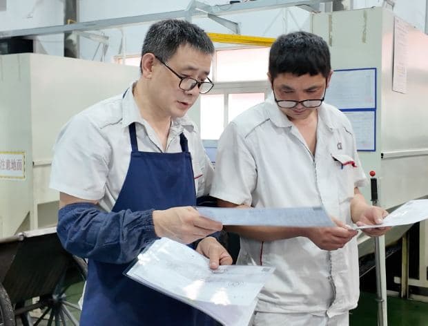 工艺老师傅在车间比对 AI 输出的工艺结果